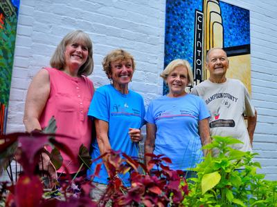 four volunteers pose for photo in downtown Clinton, NC
