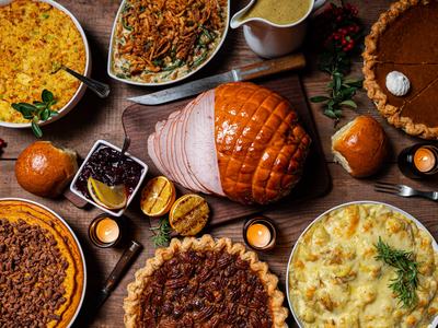 Display of traditional thanksgiving foods including pecan pie, ham, and stuffing