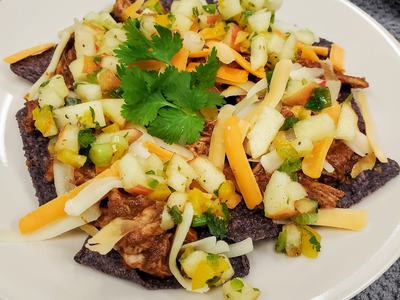 Blue corn chips topped with shredded meat, mixed cheese, apple salsa and cilantro