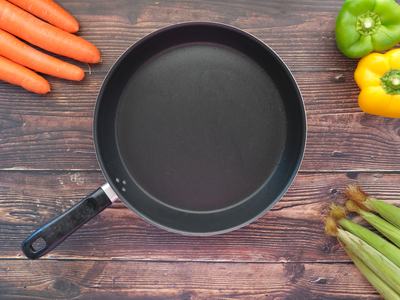 empty pan with vegetables surrounding it