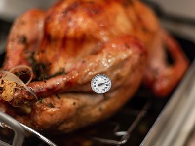 Using a meat thermometer to check if the turkey is cooked to the proper temperature