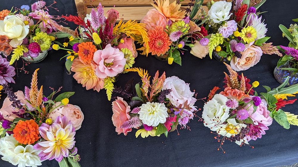 Assorted small floral arrangements displayed on a black tablecloth