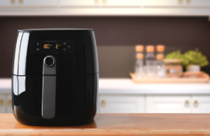 Black air fryer with digital display on a kitchen countertop