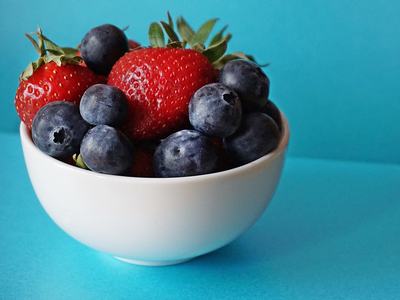 strawberries and blueberries in a white bowl