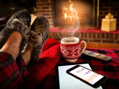 feet with slippers on, propped on ottoman with coffee,