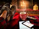 feet with slippers on, propped on ottoman with coffee,