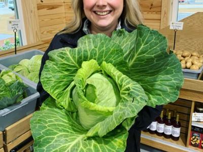 girl smiling and holding cabbage