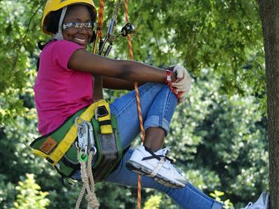 Girl climbing a tree in the JC Raulston Arboretum