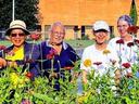 Master Gardener volunteers standing in front of bed of zinnias