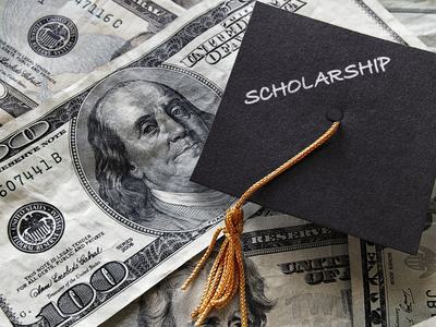 money with graduation cap and word "scholarship"