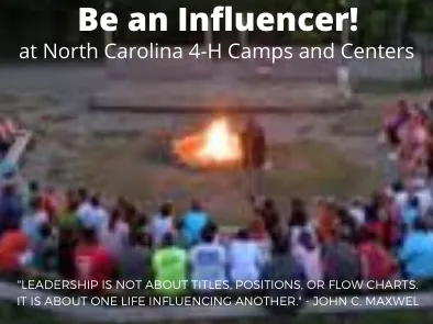 Photo of summer campers sitting around a campfire.