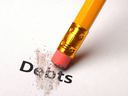 Pencil eraser rubbing out the word "Debts" on white paper.