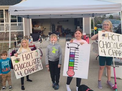 Skylar Hill (2nd from right) poses with friends in front of their hot cocoa stand. These young people donated all the proceeds to the Currituck 4-H Backpacks for Kids Program