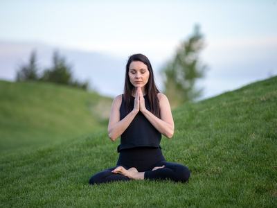 Woman Doing Yoga on Green Grass