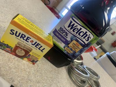 Box of Sure-Jell pectin and jug of Welch's 100% Concord grape juice on countertop