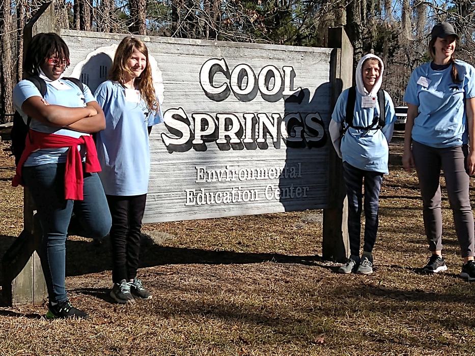 Four people standing by sign: "Cool Springs Environmental Education Center"