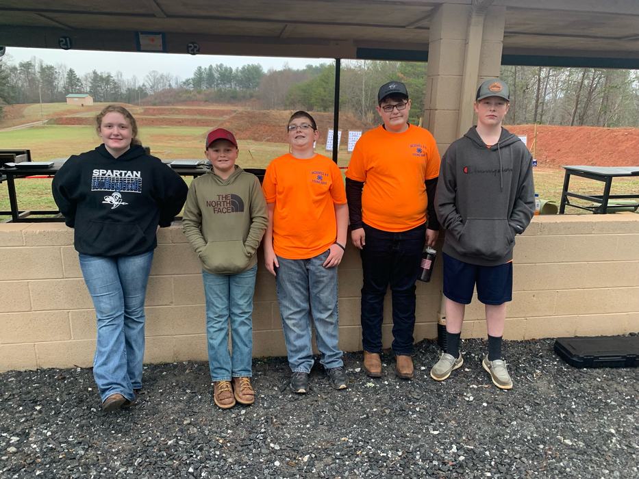 Five young people standing side-by-side under a range shelter; visible text "SPARTAN" and "The North Face"