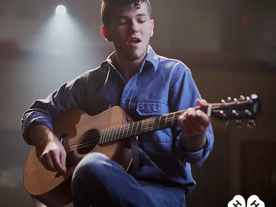 4-H member plays guitar and sings during a performance.