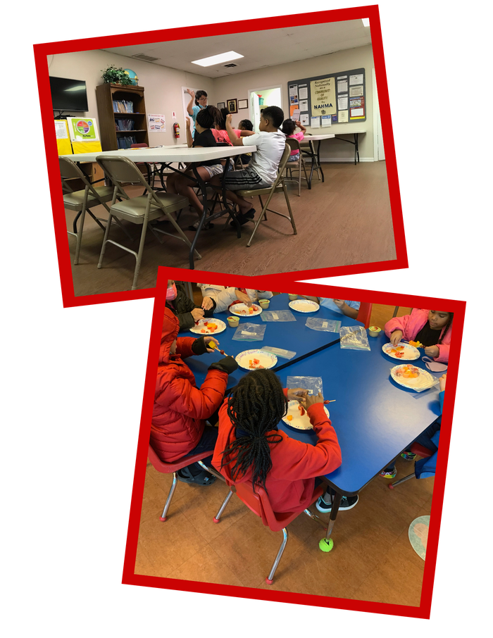 Children seated at classroom tables with teacher; other group at blue table eating from paper plates.