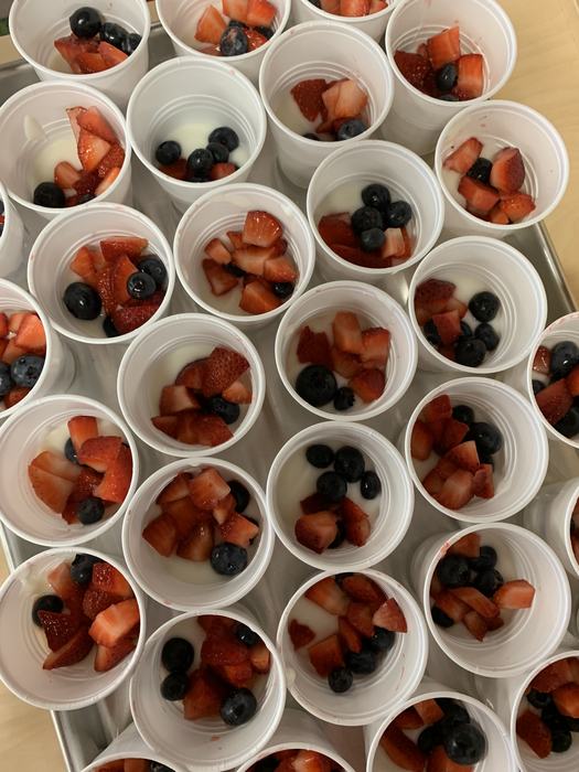 A tray of yogurt parfaits made with strawberries and blueberries.