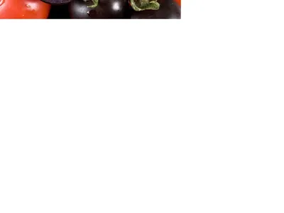 Black and red cherry tomatoes clustered, two halves showing seeds and green stems