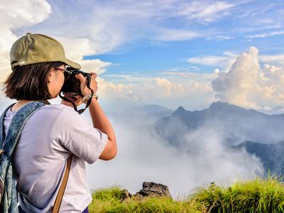 teen hiker takes a photo of a foggy mountain landscape