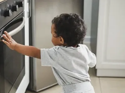 baby touching stove
