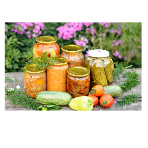 Assorted sealed glass jars of pickled vegetables and preserves with fresh produce