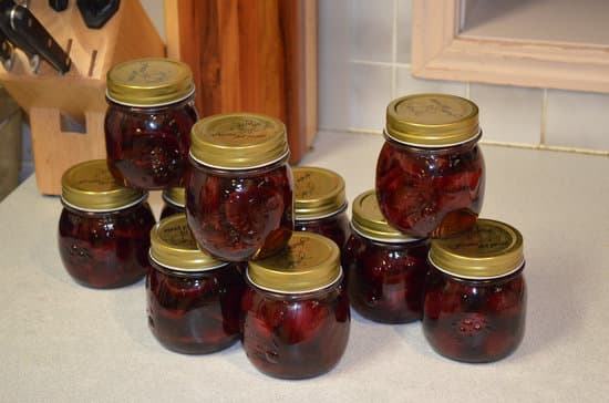 Dark red canned goods sit on a countertop. 
