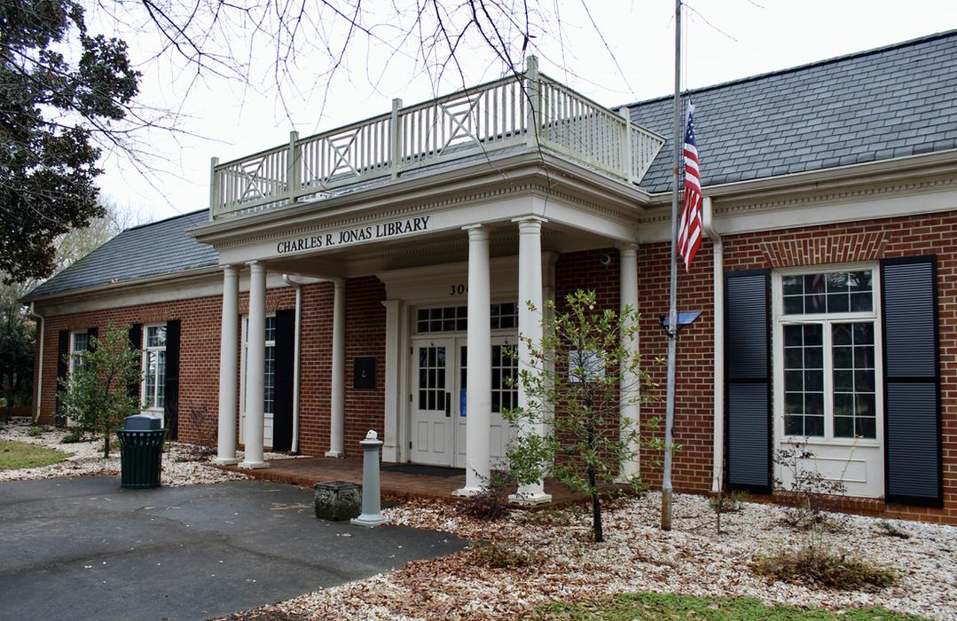 Charles R. Jonas Library brick building with columns and American flag