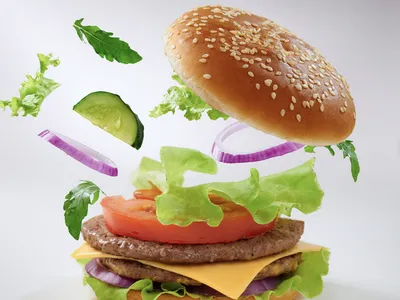 A cheeseburger with ingredients exploding upwards from the base. 