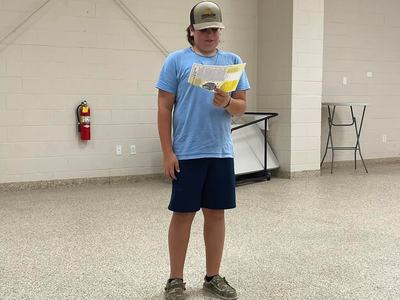 Teen standing in an empty room reading a folded paper