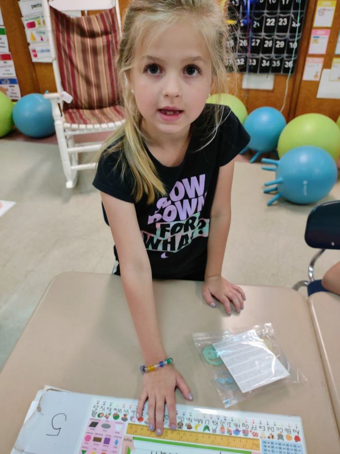 A child shows off her bee stewardship bracelet.