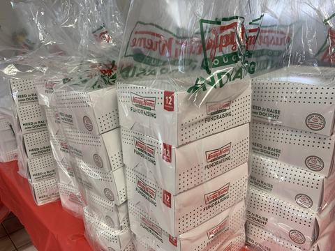 Stack of Krispy Kreme Fundraising donut boxes wrapped in clear plastic