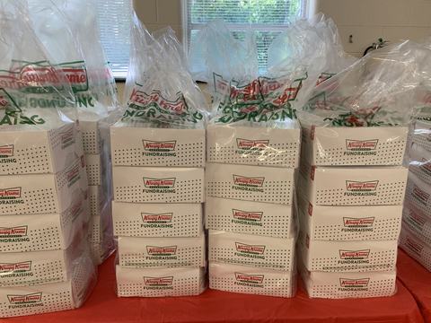 Stacks of Krispy Kreme fundraising donut boxes in plastic bags