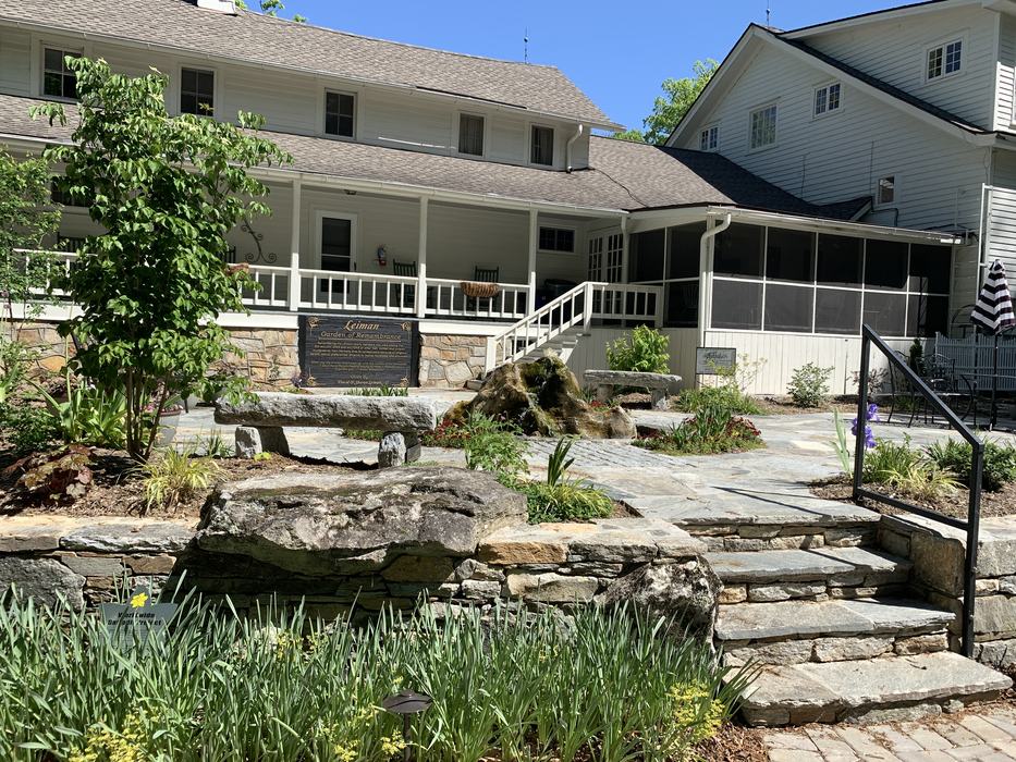Stone stairs and a small garden lead up to a large house.