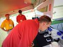 Man leaning into microscope under tent next to sign reading "Diagnostics Lab"