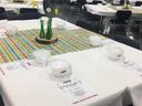 Tables set for Volunteer Appreciation Luncheon with covered bowls, menus, and daffodil centerpieces