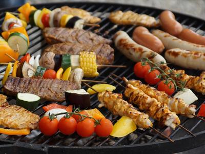 Grill with skewered chicken, sausages, steaks and assorted vegetable kebabs