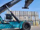 KONECRANES reach-stacker lifting a spreader above stacked shipping containers