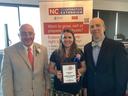 Three people posing at NC Cooperative Extension banner; woman holds plaque reading "Achievement Award Karen Blaedow State Winner"