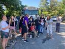 Group of people gathered in front of a bus labeled "ACTIVITY BUS", some looking up