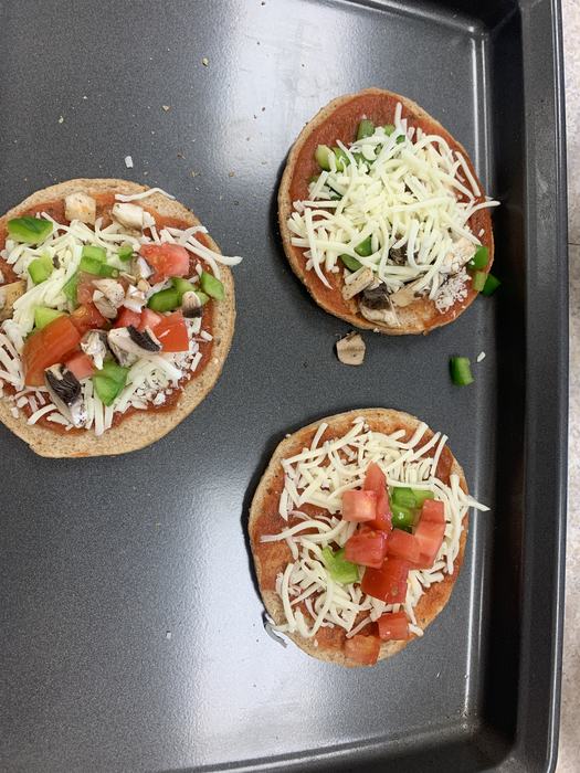 Unbaked pizza on a baking sheet.