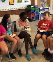2 girls and a boy tasting pesto on bread