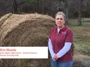 Kim Woods in front of hay.