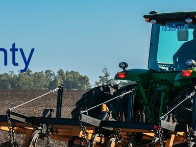 Green tractor tilling a field with large text "Farming in Nash County"