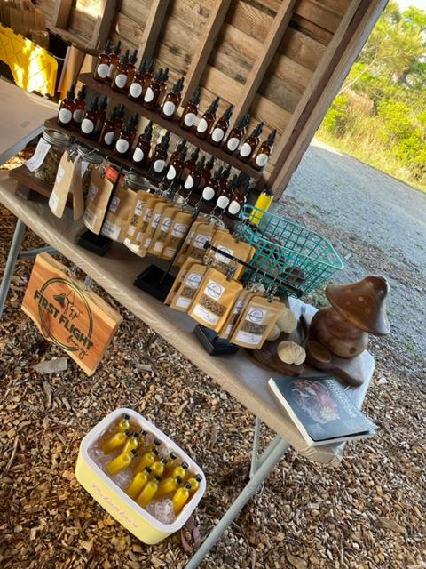 A table with various bottles and sealed packages displaying a market sign.