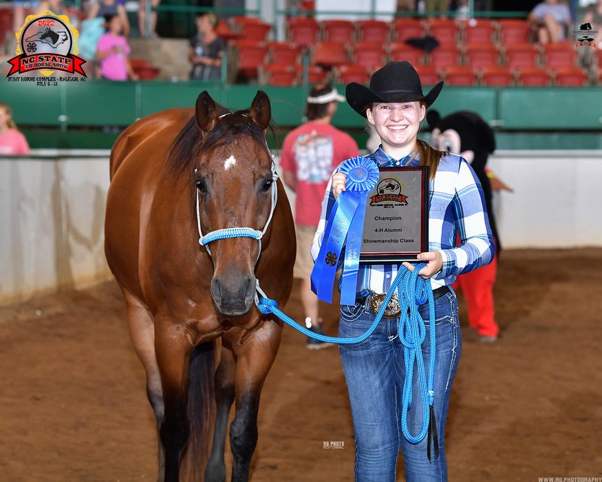 Girl in cowboy hat holding plaque reading "Champion" and blue ribbon beside brown horse