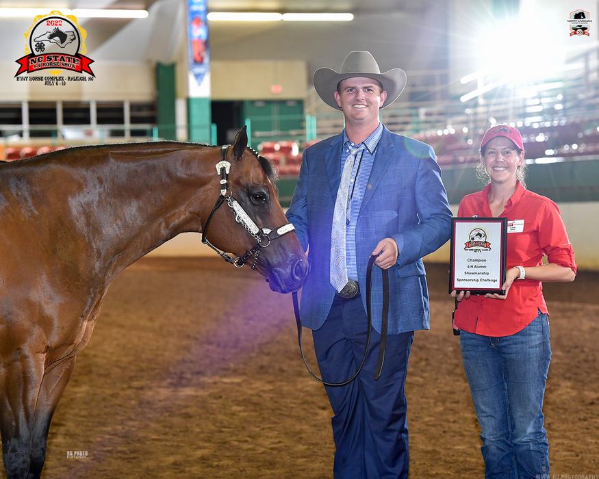 Man in cowboy hat leading horse; woman holds plaque reading "Champion 4‑H Showmanship"
