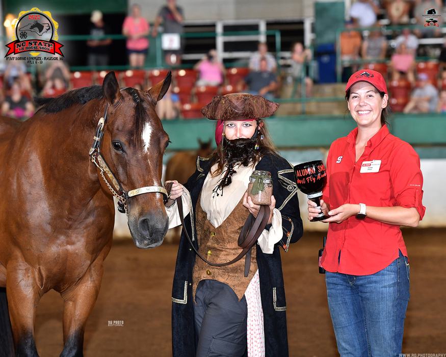 Brown horse led by person in pirate costume holding jar; woman in red holds trophy reading ALUMNI